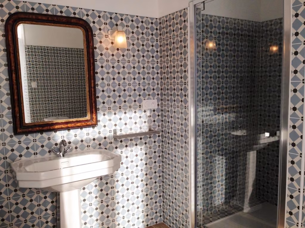 Un bagno con lavandino, doccia e specchio