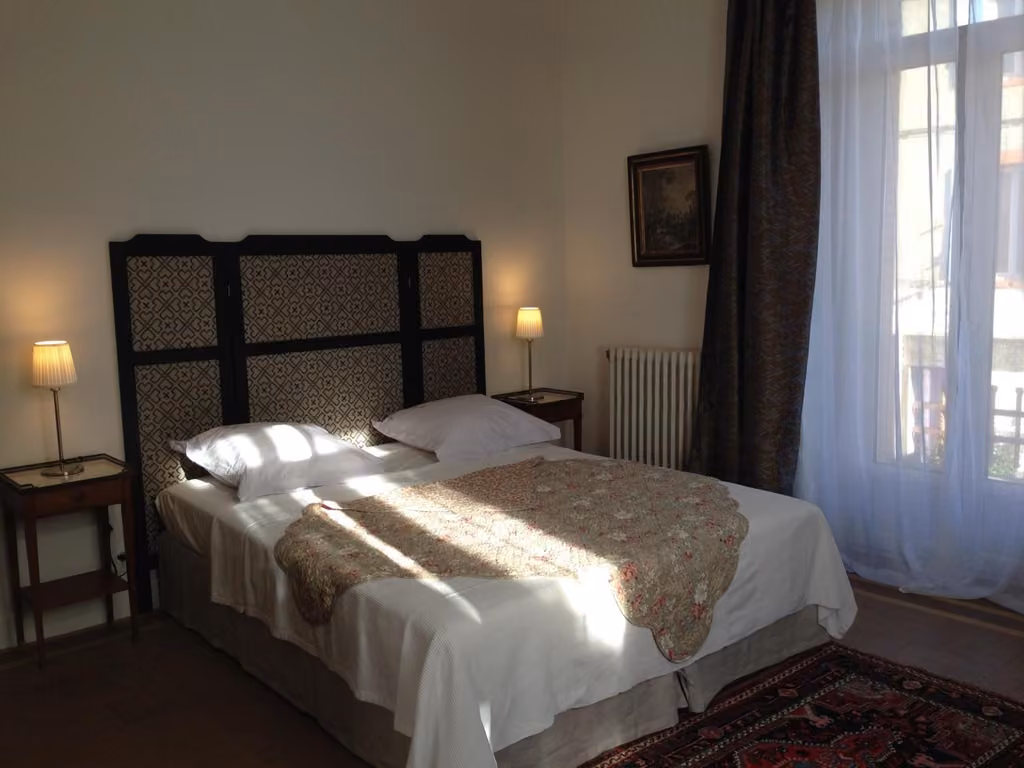 Una camera da letto con lenzuola e cuscini bianchi