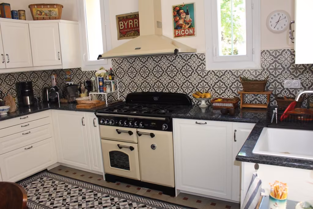 Cucina con mobili bianchi e piano cottura dell'appartamento di Villa Regina B&B